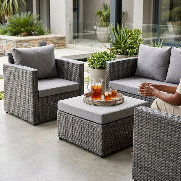 4 Piece PE Wicker Outdoor Patio Furniture in Grey arranged on a patio with drinks and cushions.