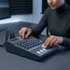 Close-up of a person using a 7-Channel USB Live Sound Mixer for audio adjustments and mixing.