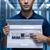 Man holding an Electrical Distribution Box with Circuit Breakers in a data center, showcasing organized electrical management.