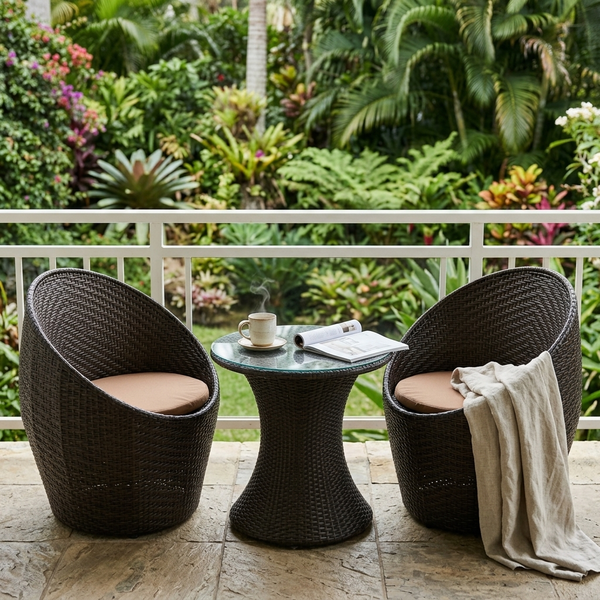 3-Piece Rattan Outdoor Bistro Set featuring two chairs and a table on a balcony with lush greenery.