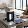 Portable Solar Home Lighting Kit Panel 3 Bulbs Torch on a desk with solar panel, light bulbs, and a laptop.