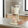 Ice Cream Machine on a countertop with a bowl of ice cream and a hand ready to serve.