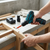 Cordless Electric Drill with Battery & Charger in use for woodworking tasks on a workbench.