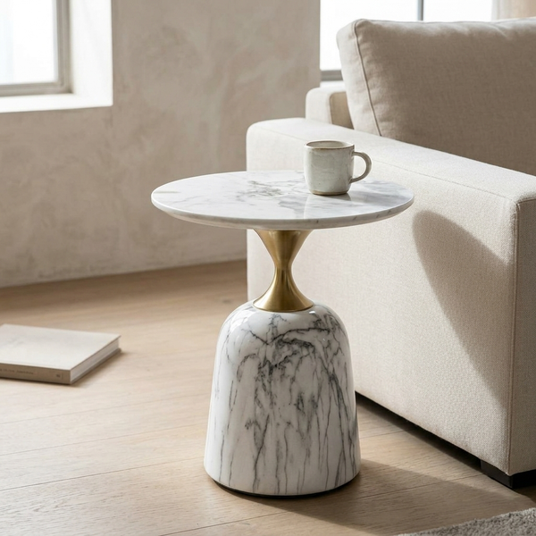Modern Round Marble-Style Side Table with a marble top and gold pedestal base, next to a beige sofa.