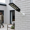 500W Solar Street Light with Motion Sensor mounted on wall near person walking outside.