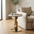 Round Pedestal Side Table in modern living room beside a cozy sofa, featuring a gold base and round marble top.