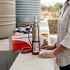 24V 50M DC Submersible Water Pump displayed next to a solar pump box, showcasing its stainless-steel construction.