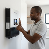 Man using the 48V 10.2kW MPPT Hybrid Solar Inverter with Wi-Fi to manage solar energy systems.