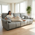 A woman relaxing on a modern 3-Seater Sofa in a bright living room, enjoying her coffee and surrounded by natural light.
