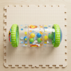 Inflatable Baby Crawling Roller Toy with Rattle Balls on a play mat with colorful rattle balls inside.