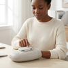 Woman using a Cordless Heated Hand Massager for relaxation at her desk.