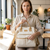 Convertible Canvas Diaper Bag Backpack with Shoulder Strap being held by a woman in a cafe.