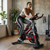 Indoor Cycling Spin Bike with Adjustable Seat in home gym with a woman cycling for cardio workout.