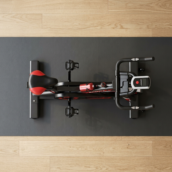 Indoor Cycling Spin Bike with Adjustable Seat viewed from above on a gym mat.