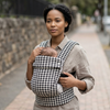 Woman using a Multi-Position Adjustable Baby Carrier & Sling to carry her baby comfortably outdoors.
