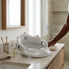 Toddler Toilet Training Seat with Handles placed on a bathroom counter next to toiletries and a towel.