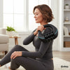 Woman using a Rolling Percussive Massage Device for personal massage at home in a cozy living room.
