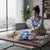 Woman enjoying the Aircraft Electric Toy on a table near a window with a cityscape view.