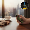 Bomb-Shaped Novelty Lighter with flame, held near a coffee cup on a wooden table, showcasing its unique design.