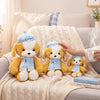 Three sizes of Beret Puppy Plush Toy displayed on a cozy couch, featuring playful puppy designs with blue checkered scarves.