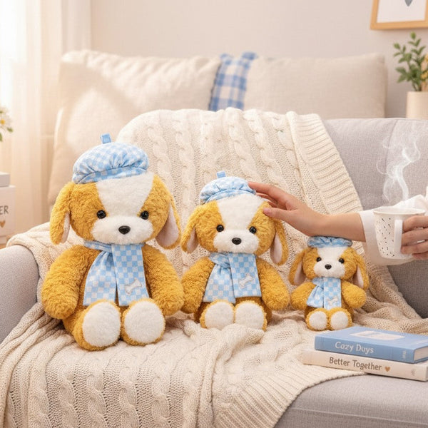 Three sizes of Beret Puppy Plush Toy displayed on a cozy couch, featuring playful puppy designs with blue checkered scarves.