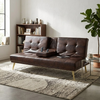 Modern Tufted Faux Leather Sleeper Couch in stylish living room setting with decorative items and plants.