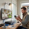 Man setting up the 3MP 16-Channel NVR PoE Security Camera Kit with a monitor displaying security footage.