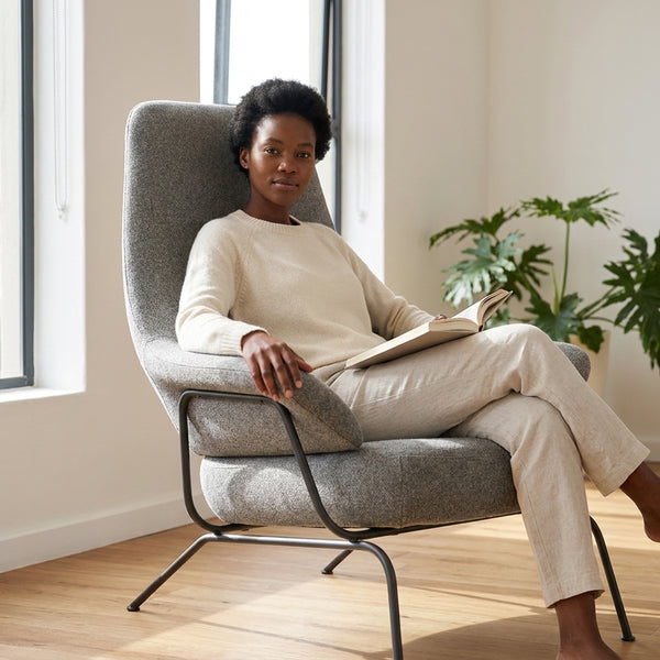 Zen Lounge Chair featuring a woman reading comfortably in a modern, minimalist design with a sleek frame and spacious seat.