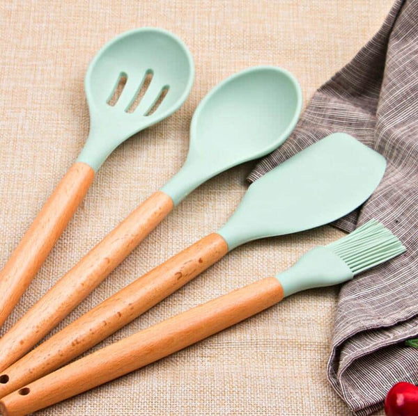 11 Piece Silicone Kitchen Utensil Set featuring mint green utensils with wooden handles on a beige surface.