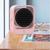 Portable Energy Efficient Desktop Heater on a wooden desk next to glasses and magazines, providing quick warmth.