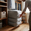 Multi-Layer Fabric Compression Storage Bag stacked neatly in a closet, ideal for organizing clothing and household items.