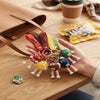 A hand holding multiple 3D Candy Character Keychains in the form of M&M characters on a table.