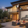 3MP 16-Channel NVR PoE Security Camera Kit: A family enjoying time around a fire pit outside a modern home, showcasing a 3MP 16-Channel NVR PoE Security Camera.