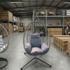 Indoor Outdoor Swing Egg Chair hanging in a spacious interior with decorative cushions for relaxation.