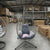 Indoor Outdoor Swing Egg Chair hanging in a spacious interior with decorative cushions for relaxation.