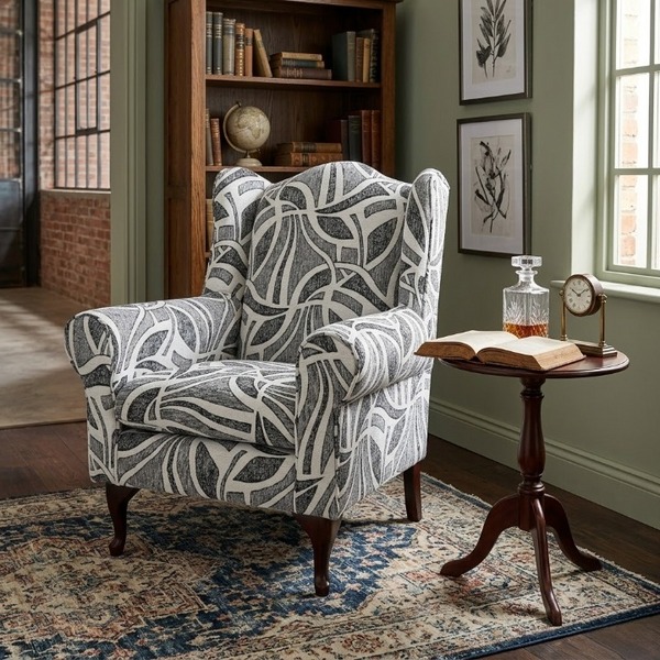 Serena Grey Fabric Wingback Chair in a stylish living space with a vintage side table and bookshelf.
