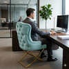 Man sitting on a Cassander Dining Chair at a modern office desk with plants and a computer.