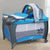 Alloy Portable Simplistic Portable Crib features a blue design with a canopy and rolling wheels for easy movement.