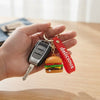 Snack Pop 3D Fast-Food Keychain featuring a burger design attached to a keychain with keys in hand.