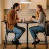 Modern Vintage Plastic Bar Chair in a cozy setting, with two people enjoying drinks at a kitchen counter.