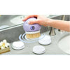Using the Complete Body Care System Brush for skin exfoliation and cleansing at a bathroom sink.