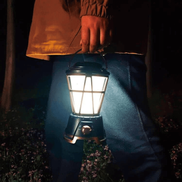 Person holding an Outdoor Flicker LED Lantern during a camping night for ambient lighting.