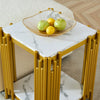 2 Tier Faux Marble Side Table with golden legs and a bowl of fruits on top.