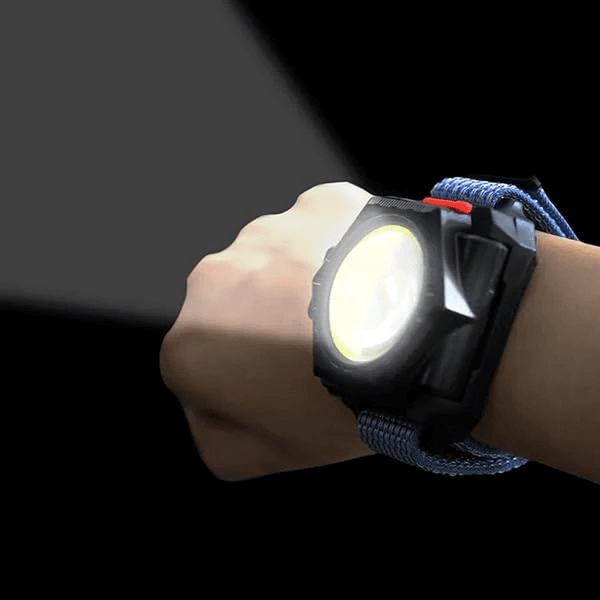 Close-up of a hand wearing a 3-in-1 Rechargeable LED Utility Headlamp projecting light.