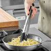 Durable Stainless Steel and Silicone Kitchen Tong mixing pasta in a skillet on a kitchen stove.