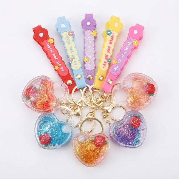 Colorful Heart-Shaped Liquid Glitter Keychains arranged with text straps, showcasing vibrant glitter-filled designs.