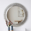 Sunburst Decorative Round Wall Mirror with metallic spikes and floral arrangement in front, enhancing interior decor.