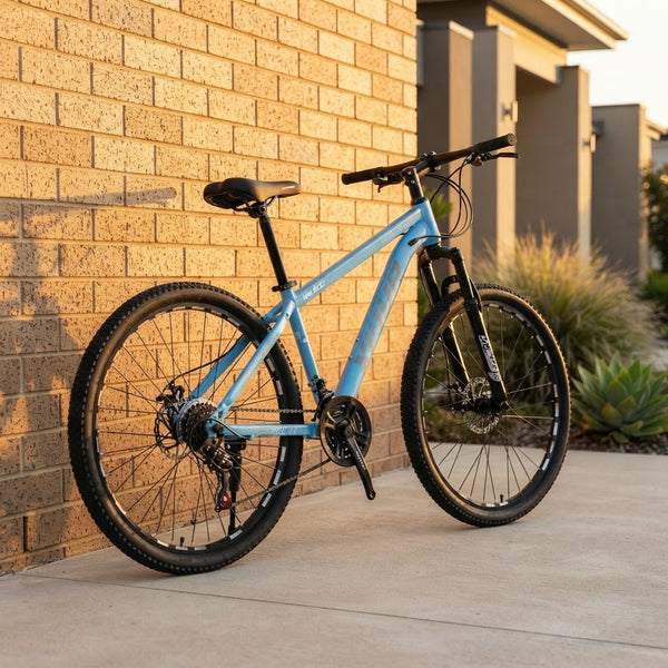 Mountain Bike with Suspension Fork & Triple Chainset leaning against a brick wall in a serene outdoor setting.