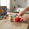 Child playing with the 12-Piece Colorful Stackable Spinning Top Set, featuring colorful spinning tops and a wooden table.