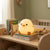 Squishy Silicone Duck Night Light glowing softly on a shelf with children's books and toys.